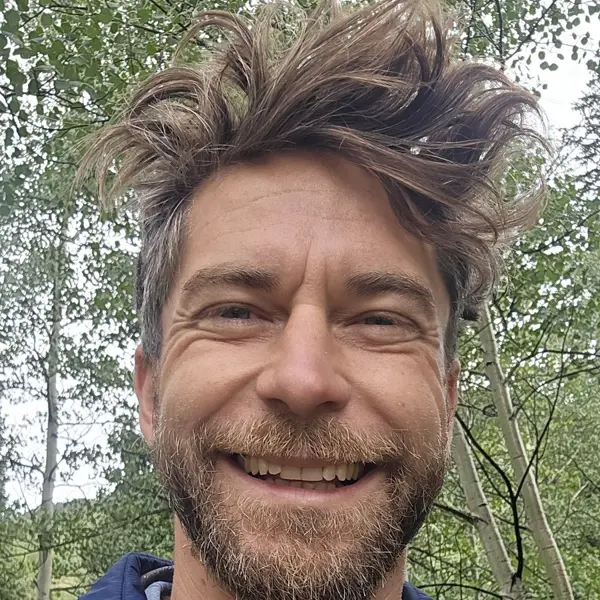 Scott smiling among aspen trees